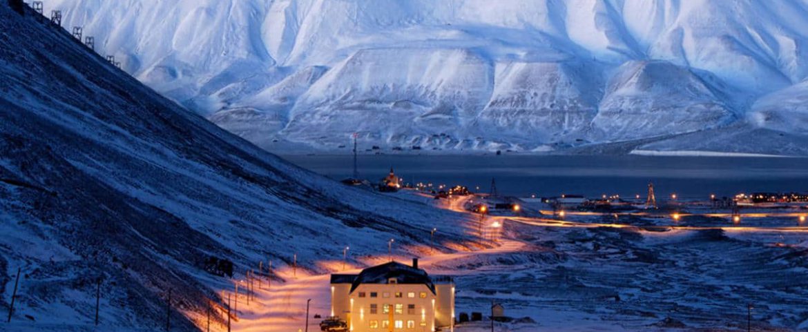 Snow-covered mountain landscape with building.