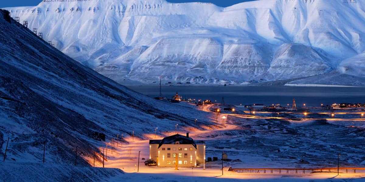 Snow-covered mountain landscape with building.