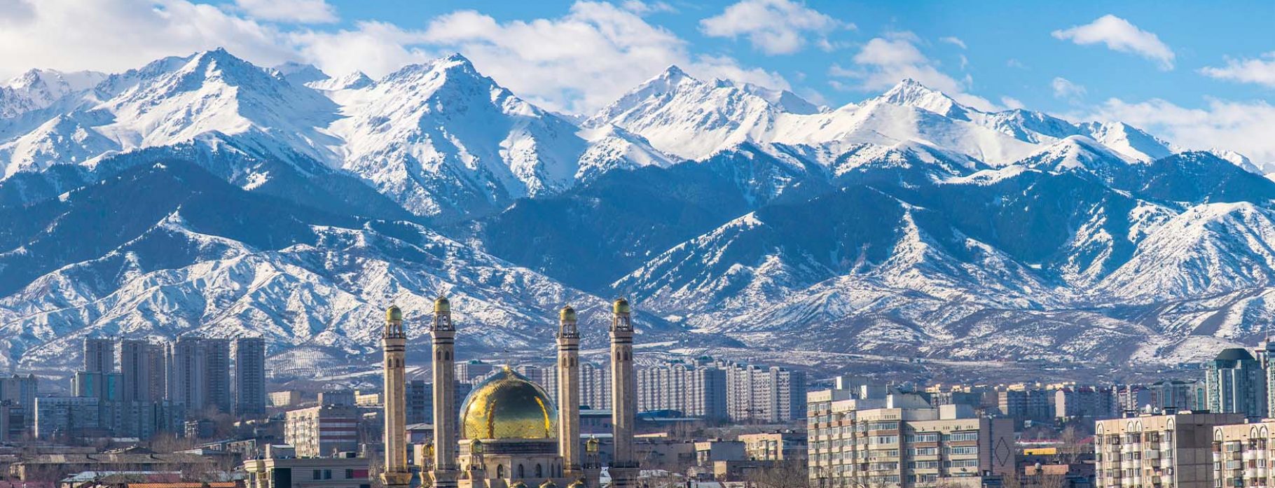 Snowy mountain range with buildings in winter.