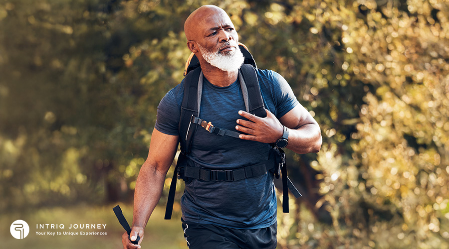 A fit, senior man with a white beard wearing a technical hiking backpack and activewear