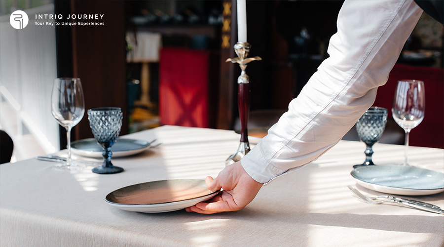 Server setting a fine dining table for a luxury experience.