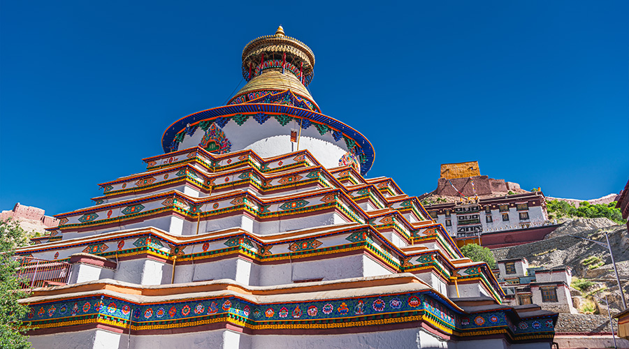 Large white and colorful Tibetan stupa monument reaching toward the sky.