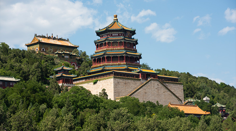 Traditional multi-tiered Chinese pagoda temple surrounded by lush green trees.