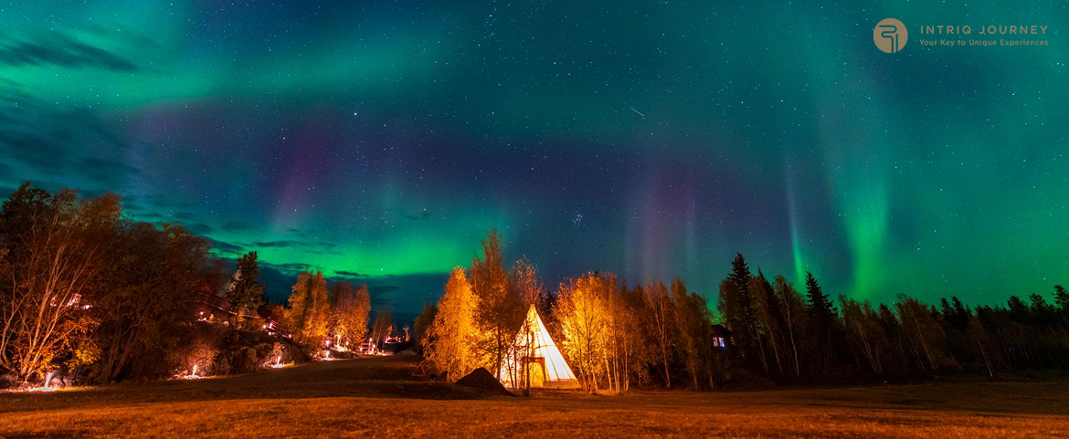 Northern Lights illuminating the sky over a luxury camping site.