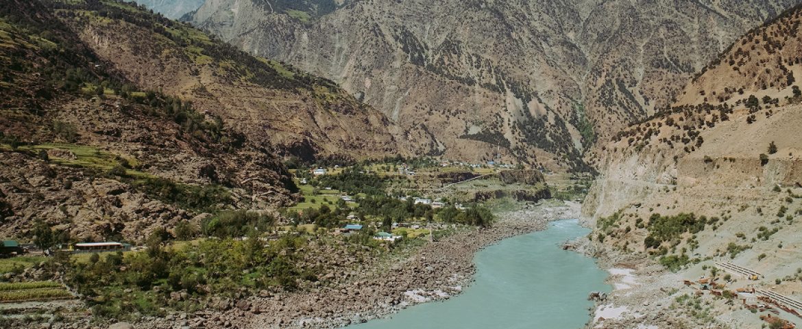 Scenic river flowing through a Tibetan mountain valley landscape.